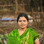 A woman in vibrant green sari posing outdoors in India.